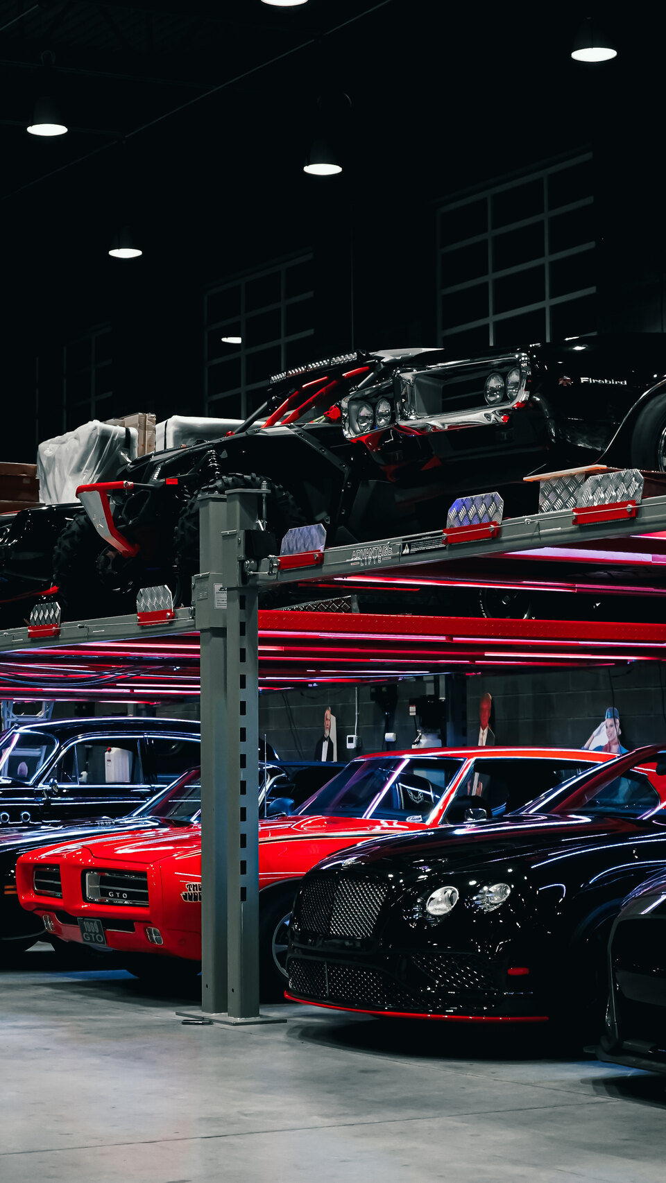 Private automotive collection displayed across two levels of a custom garage.