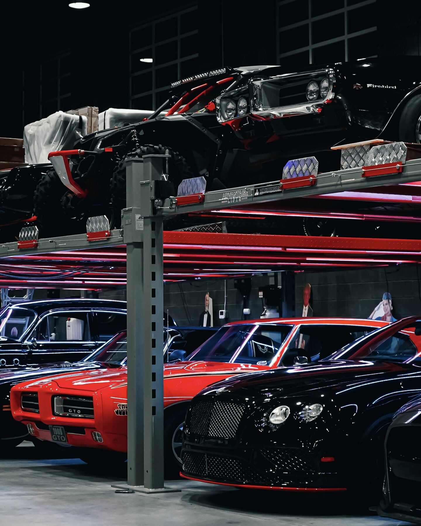 Multilevel private automotive collection filled with classic cars and off-road vehicles.