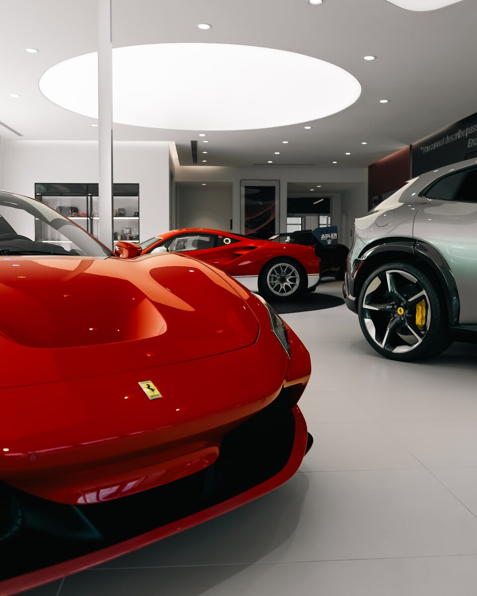 Red Ferrari sports cars arranged inside a modern showroom.