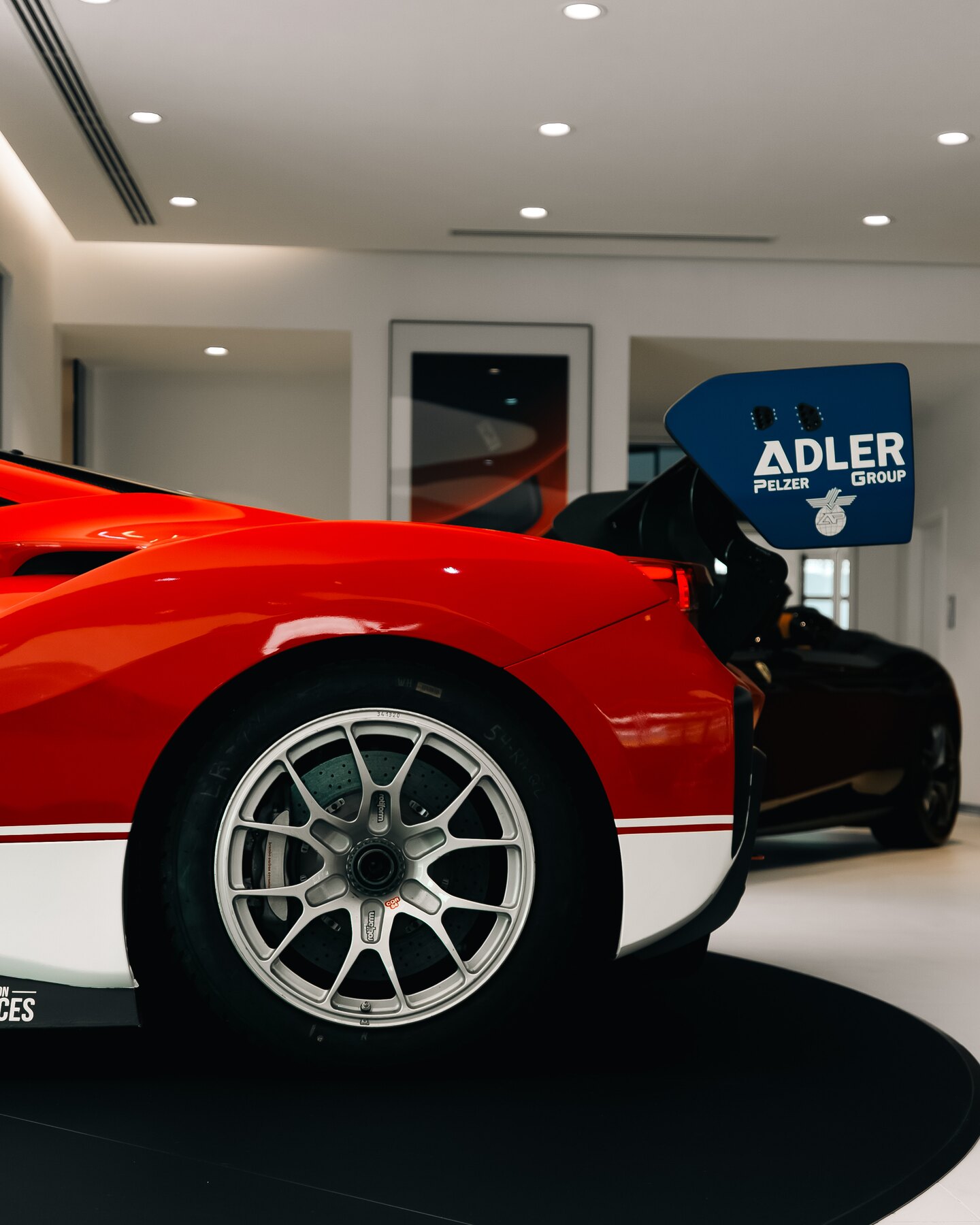 Close view of a Ferrari race car wheel, bodywork, and rear wing.