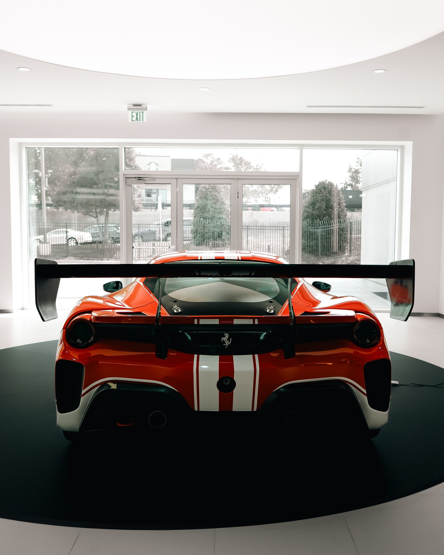 Rear view of a red and white Ferrari race car beneath its wing.