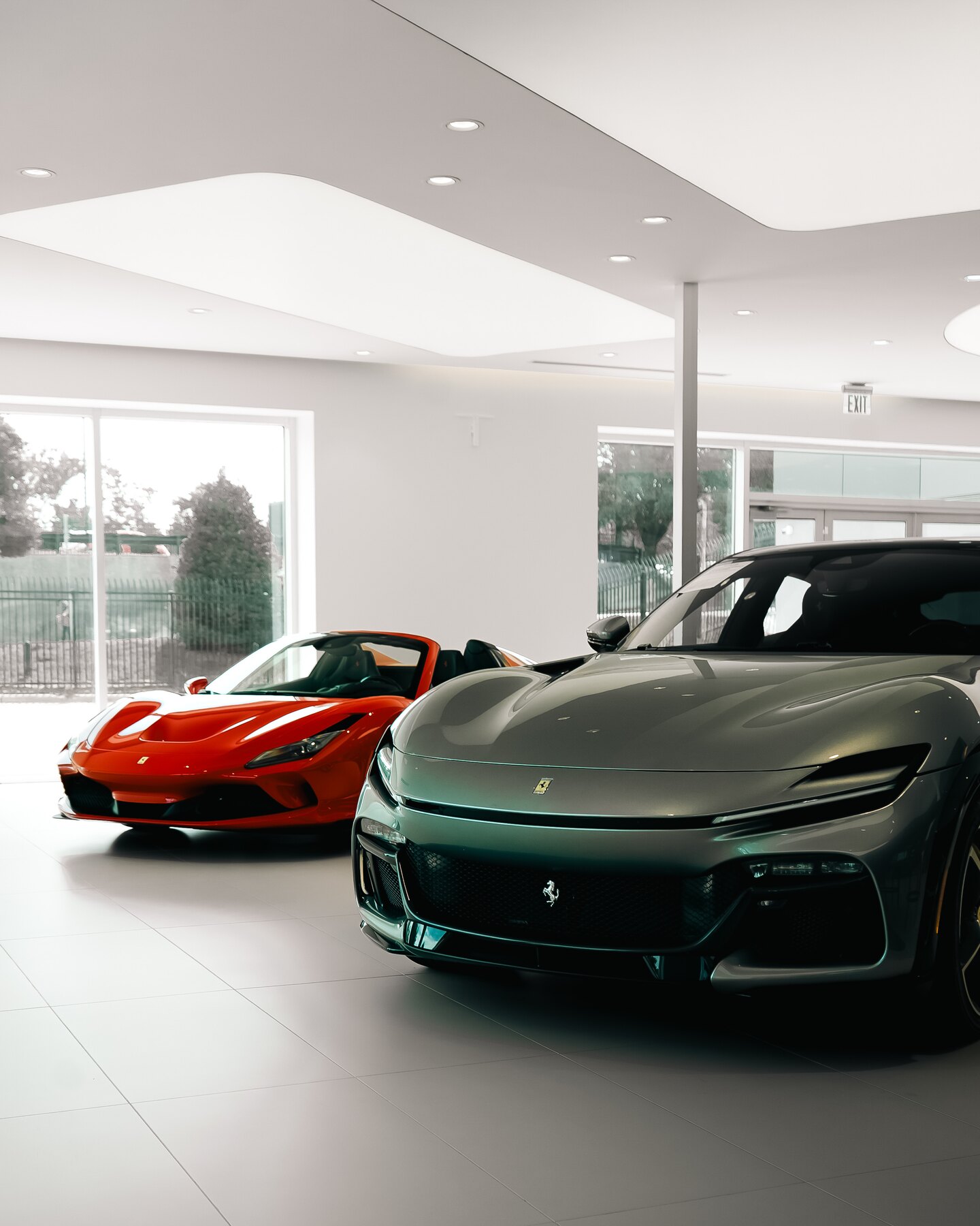 Gray and red Ferrari models arranged together inside the showroom.