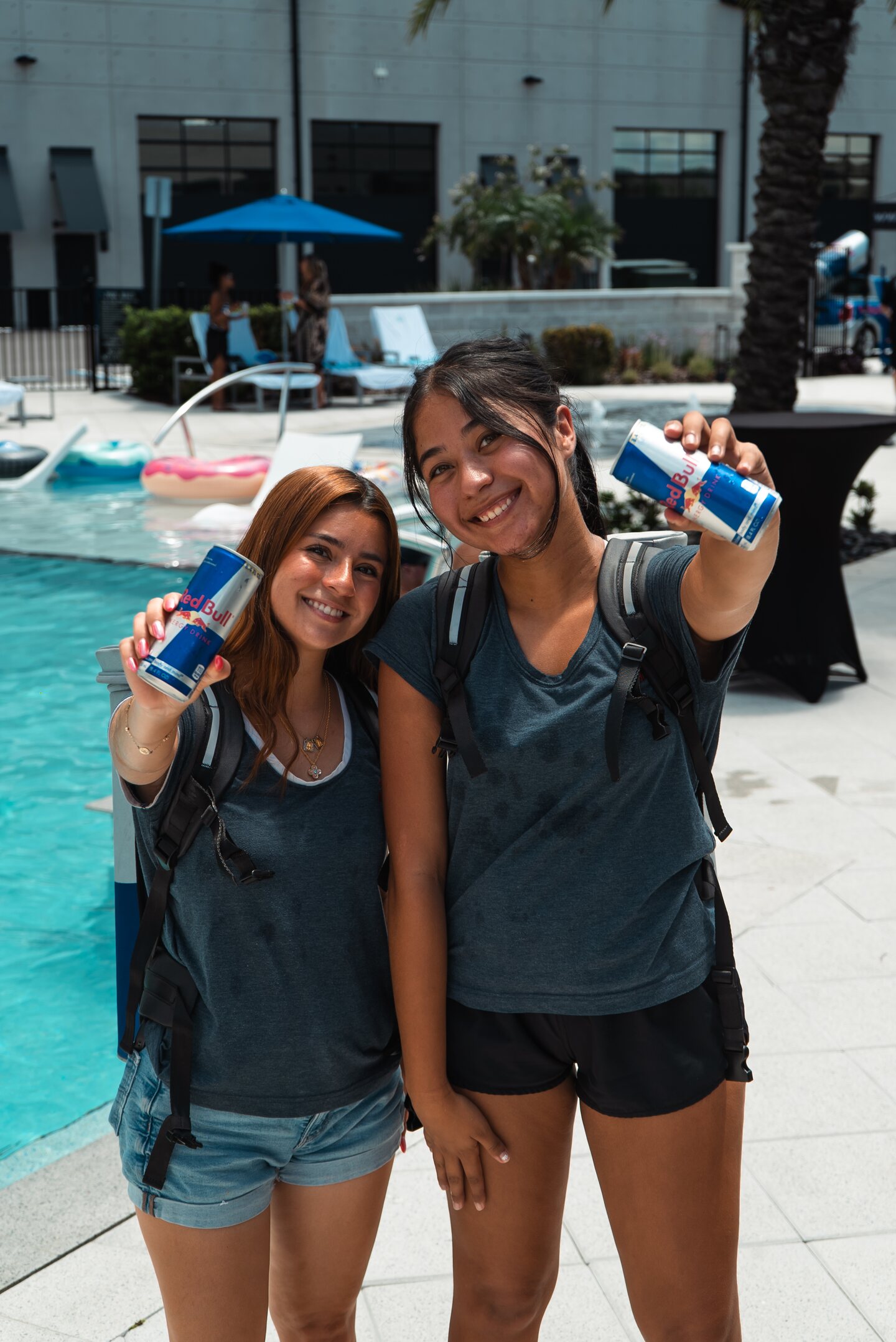 Two guests posing together beside the pool at The Motor Enclave.